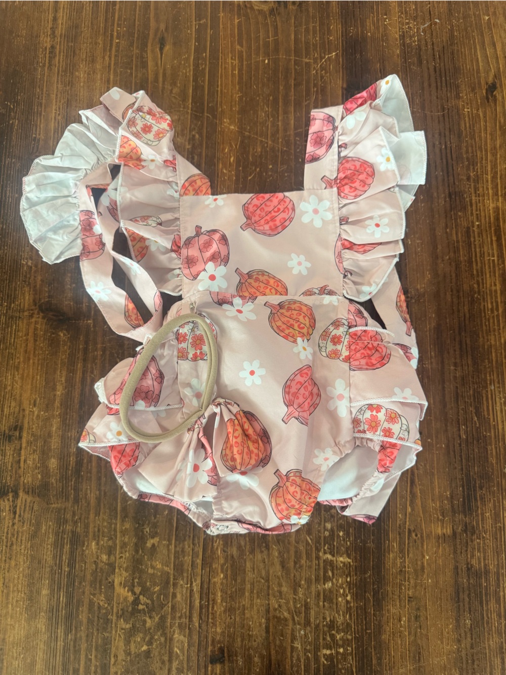 Source Unknown Pink Pumpkin & Daisy Ruffle Baby Romper with matching bow.